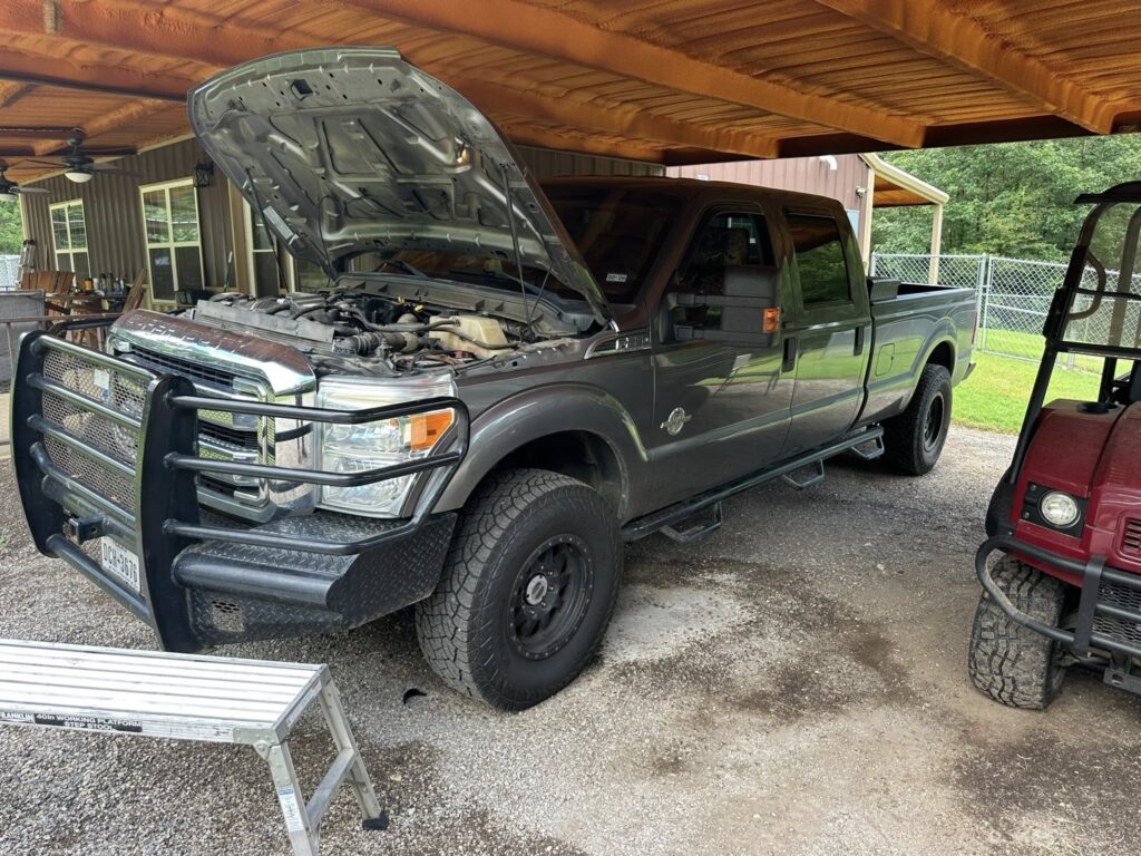 Diesel truck engine repair with hood open in East Texas